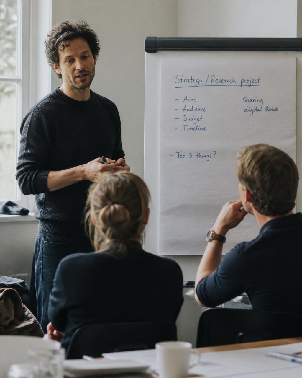 Practitioner begeleidt een werksessie bij een flip-over